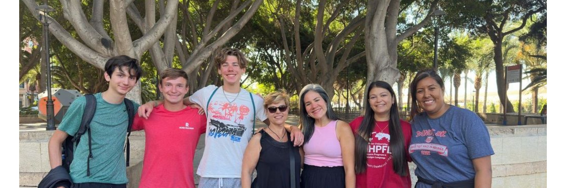 Instructors and students pose in front of a tree