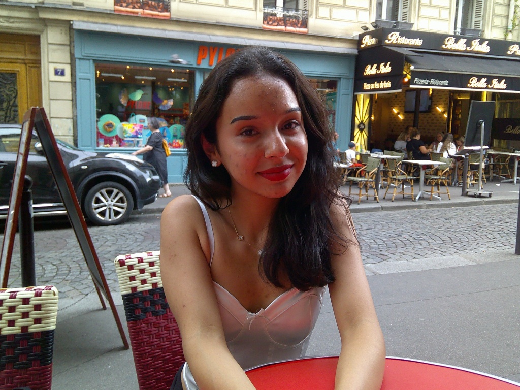 A girl smiles slightly at the camera in France