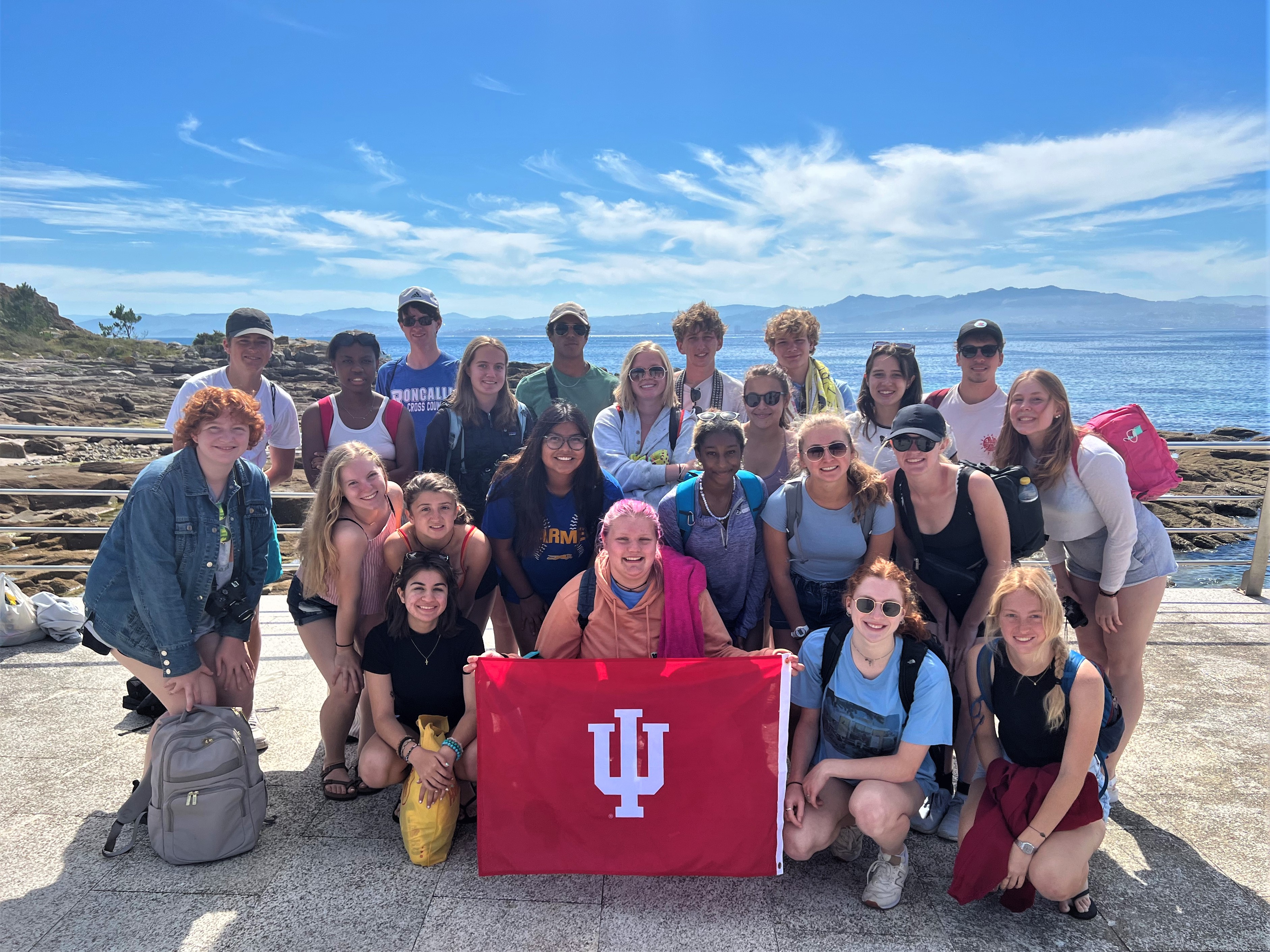 Group of students with IU flag in front of a body of water