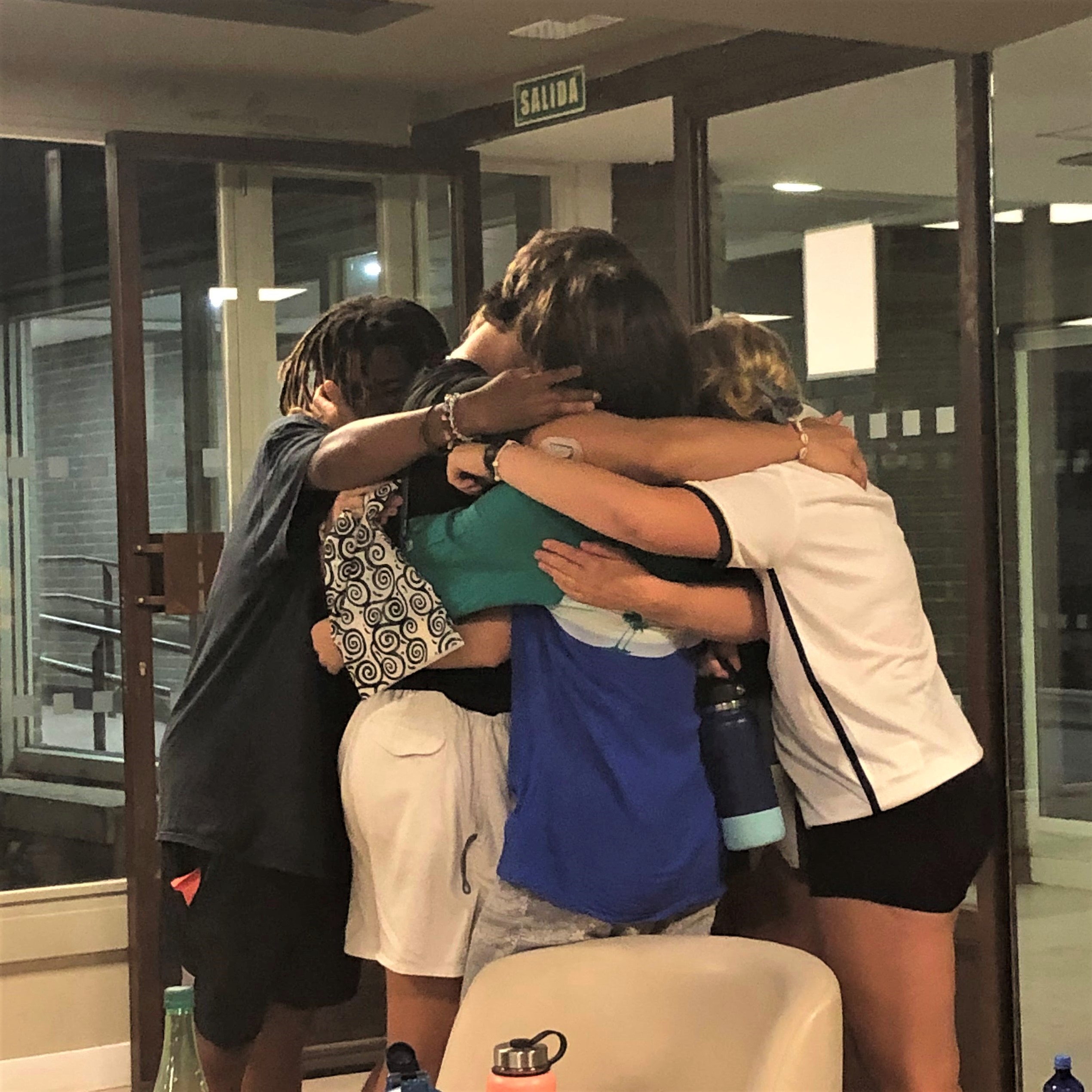 A group of students hugs